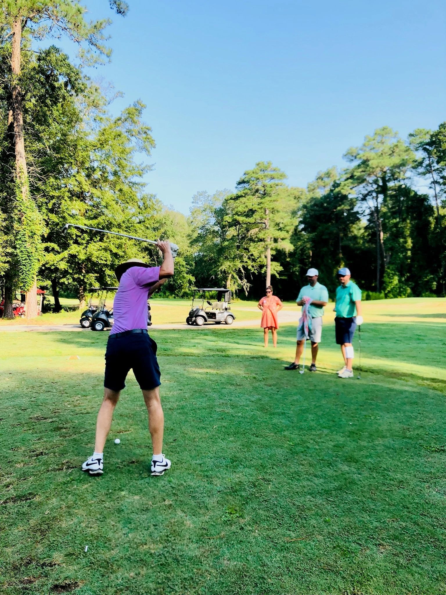 Golfer mid swing on fairway
