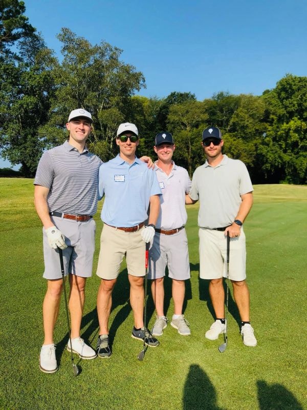 Four golfers posing on fairway