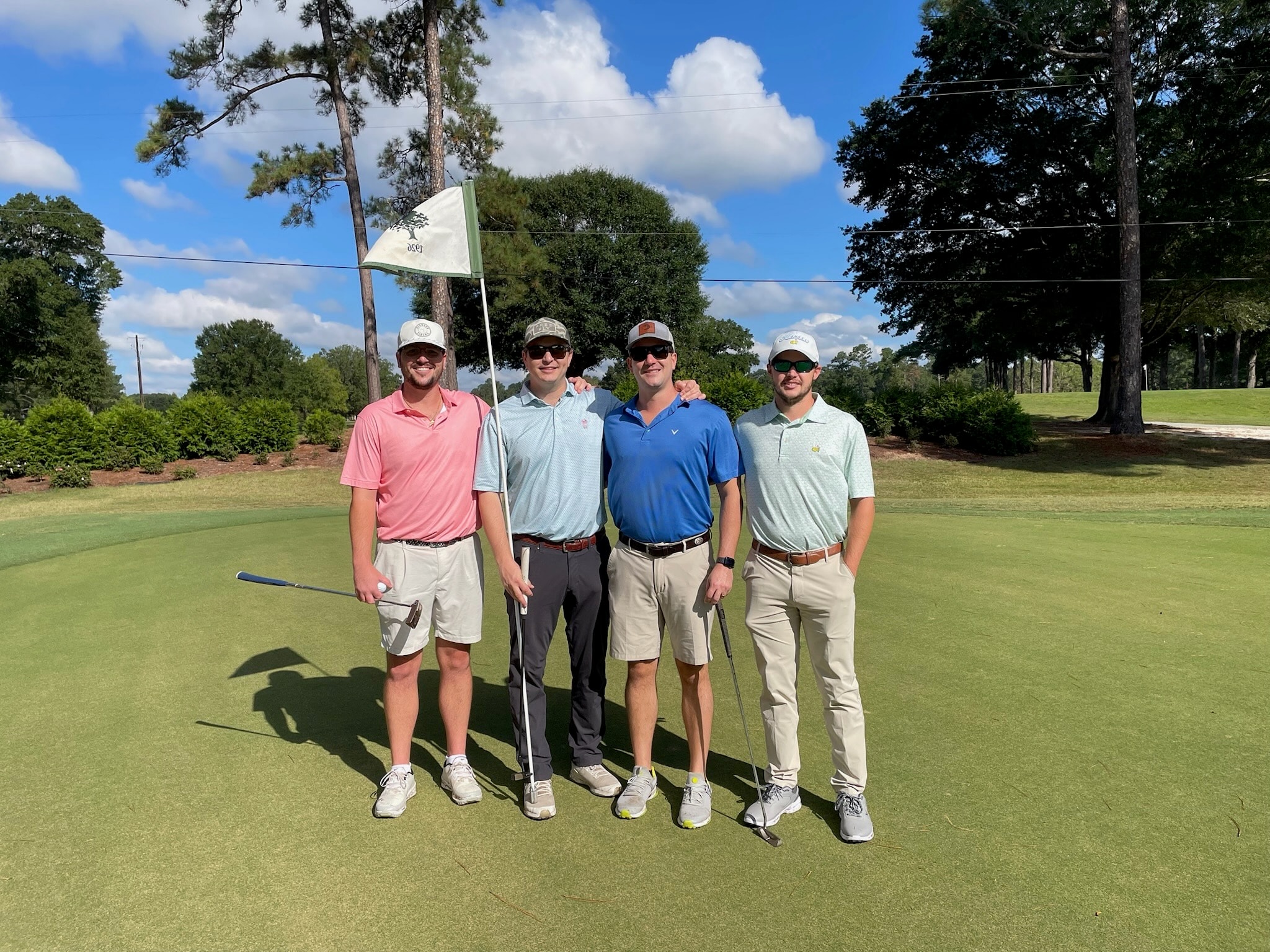 Four golfers posing on the green